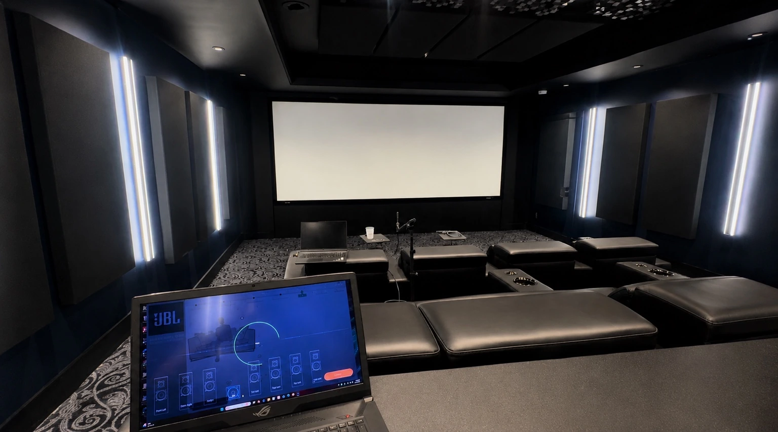 Private home cinema with projection screen and calibration laptop
